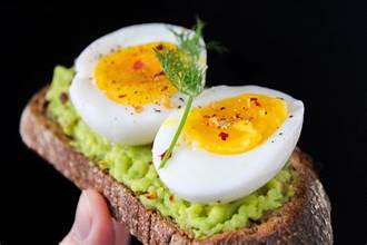 avocado toast with a hard boiled egg cut in half on top